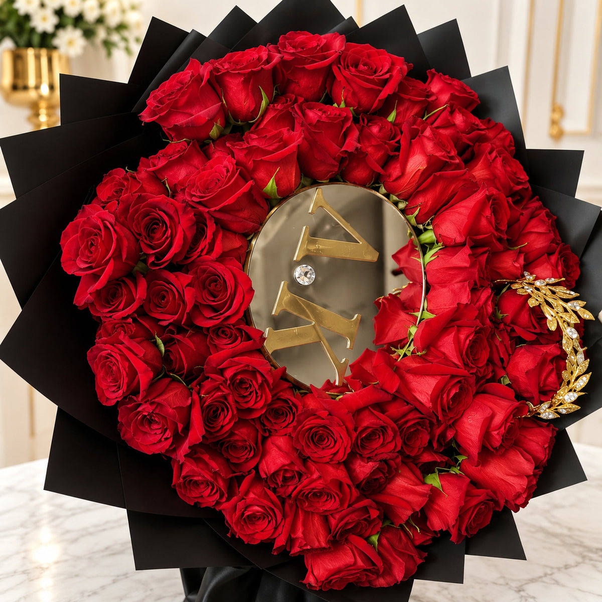 Bouquet de roses rouges prestige, miroir central doré avec initiales A.K., emballage noir et couronne dorée – Les Fleurs de Chelsea